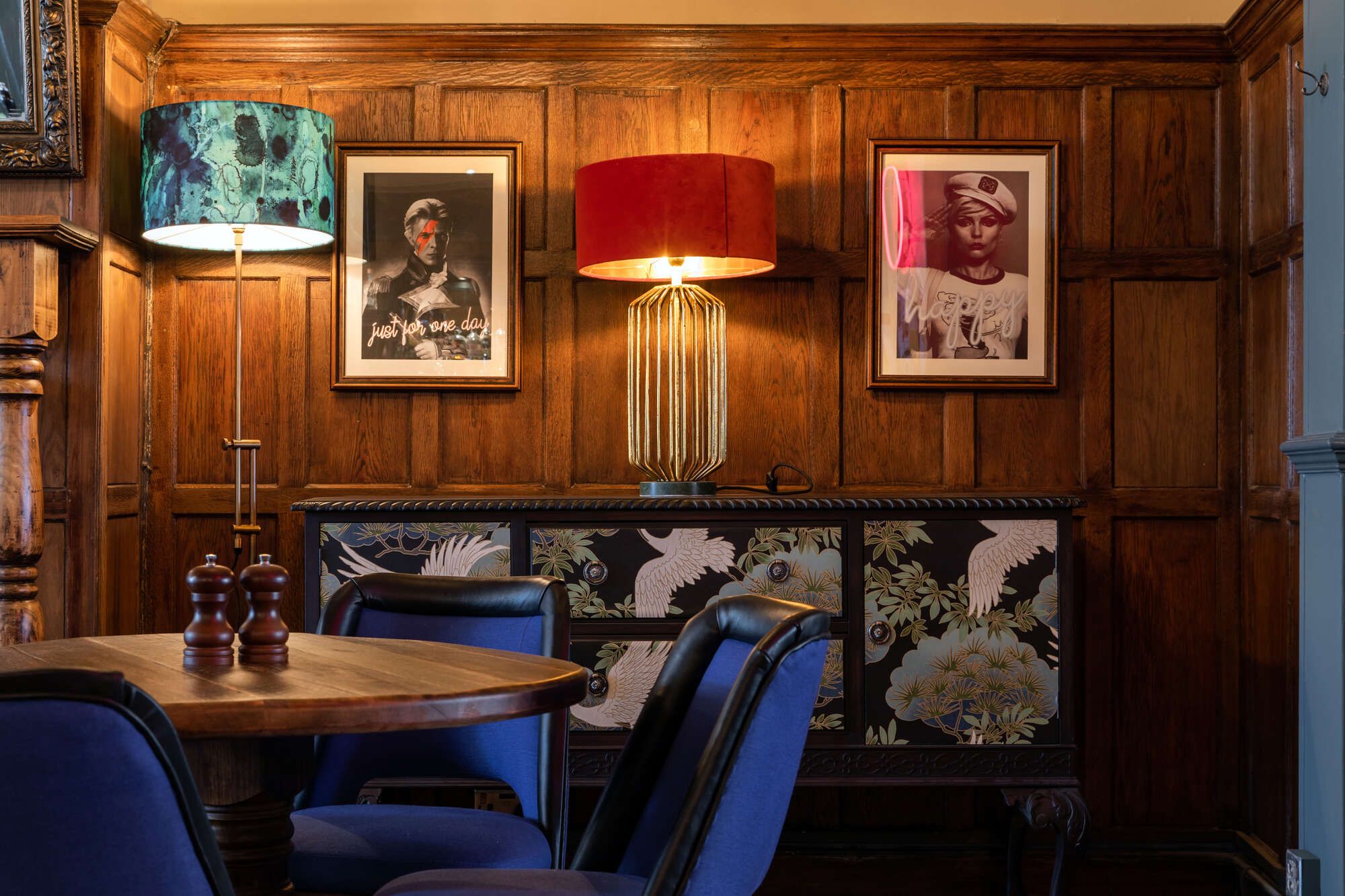 Paintings and wall fixtures on wall next to tables at Cock tavern