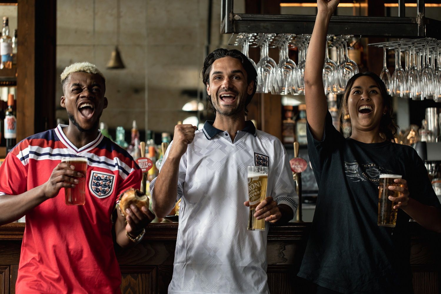 friends in a Young's pub drinking pints and cheering