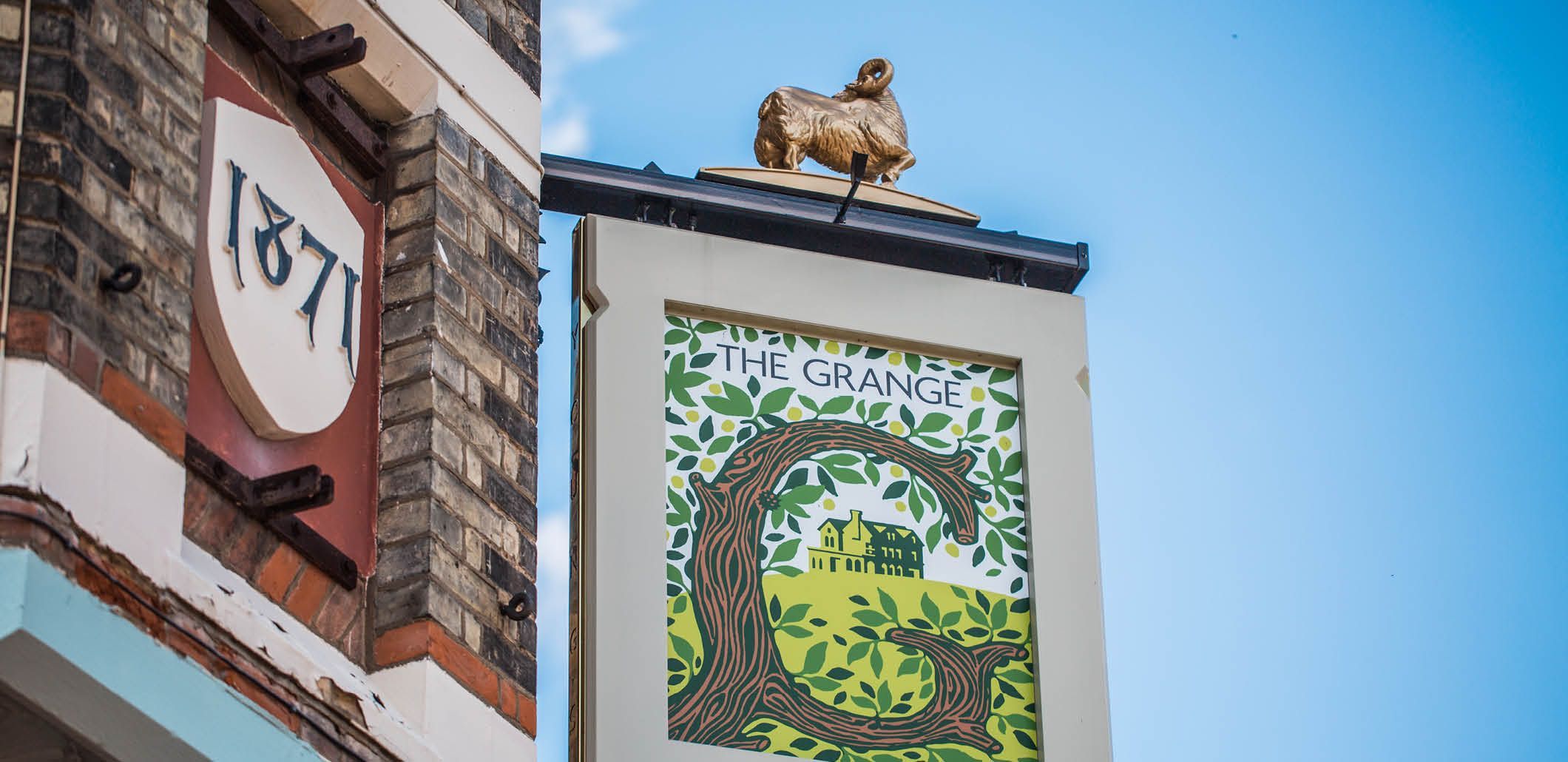 pub sign with sheep statue that reads "The Grange (1871)."